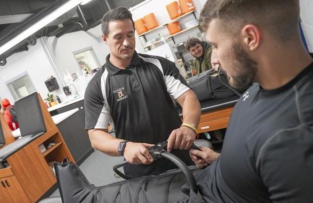 Two students work in a physical therapy setting